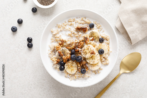 Oatmeal bowl. Oat porridge with banana, blueberry, walnut, chia seeds and almond milk for healthy breakfast or lunch. Healthy food, diet. Top view. photo