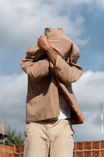 Fashionable man covering himself with his jacket