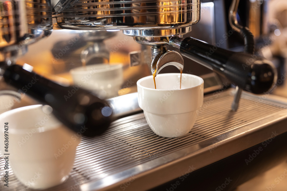 Coffeemaker pouring hot drink in cup Coffeemaker pouring hot drink in cup