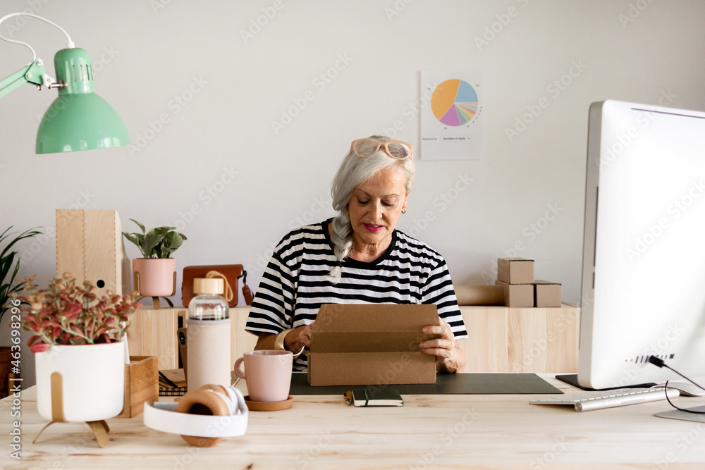 Senior woman preparing a package at office Senior woman preparing a package at office