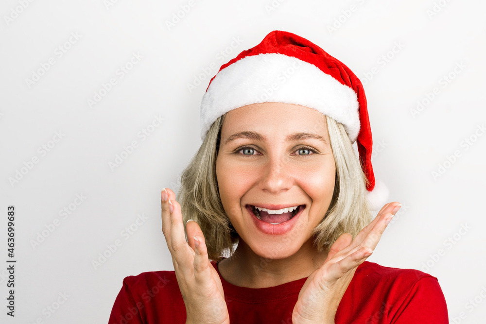 Young beautiful girl with Santa Claus accessories such as Santa's Cap and red outfit isolated on white background. Photo for Christmas. Brazilian, Caucasian, blonde hair, green eyes. Young beautiful girl with Santa Claus accessories such as Santa's Cap and red outfit isolated on white background. Photo for Christmas. Brazilian, Caucasian, blonde hair, green eyes.