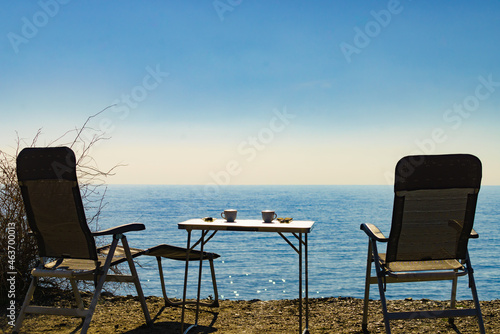 Coffee cups on sea shore. Travel outdoor picnic.