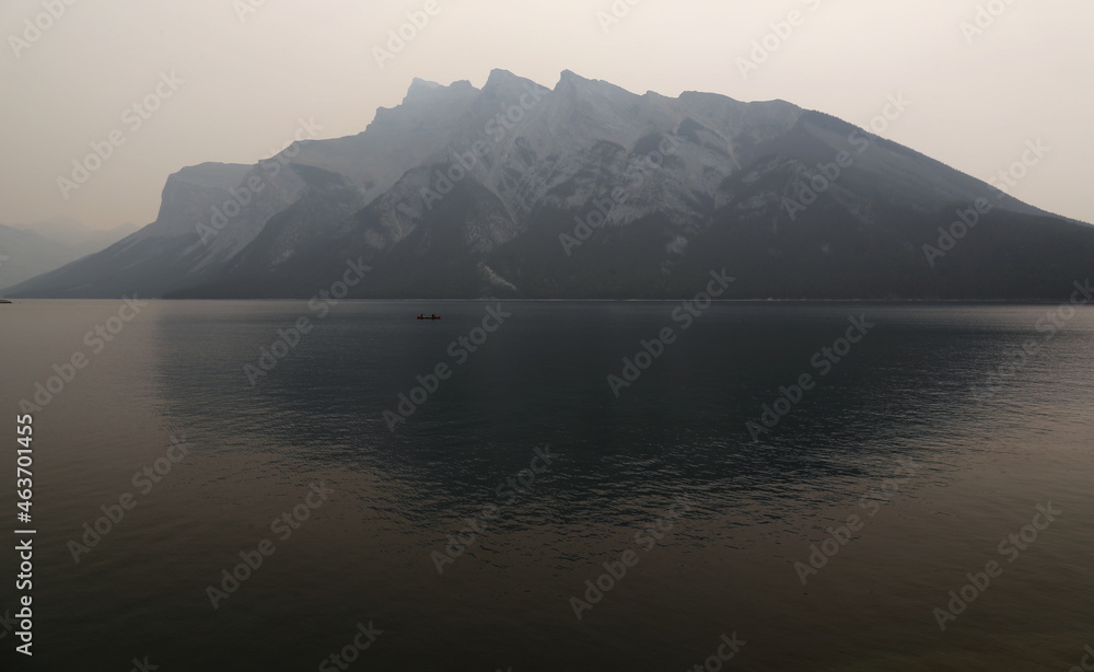 Shot during the summer of 2021, in which wild fires ravaged much of neighbouring BC. Resulting in a very smoky Lake Minnewanka, with canoers and Mount Girouard in the background. Shot during the summer of 2021, in which wild fires ravaged much of neighbouring BC. Resulting in a very smoky Lake Minnewanka, with canoers and Mount Girouard in the background.
