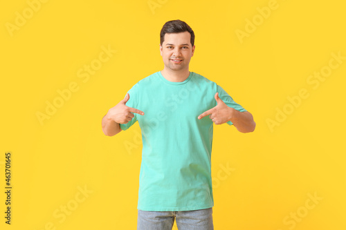 Handsome young man in stylish t-shirt on color background