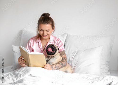 Young woman with cute pug d...