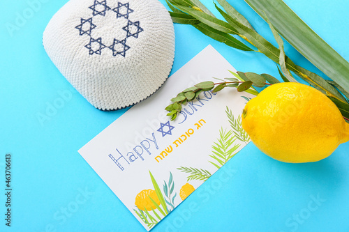 Sukkot festival symbols and greeting card on color background photo