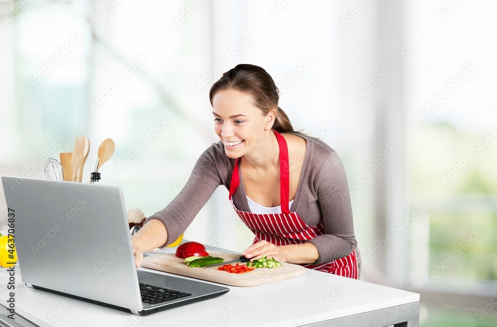Online ordering, cooking eat, healthy food. Cheerful young woman in kitchen interior Online ordering, cooking eat, healthy food. Cheerful young woman in kitchen interior