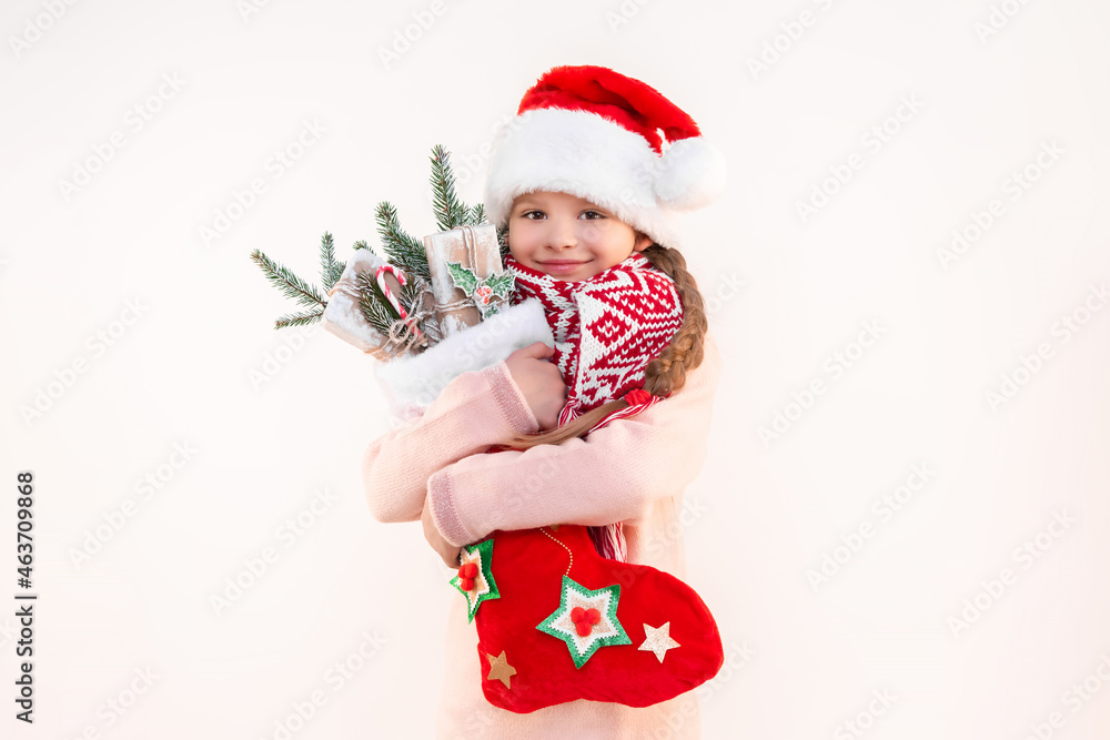 A little girl in a beautiful outfit for the new year holds a lot of gifts and jewelry in her hands. A girl on an isolated background. A little girl in a beautiful outfit for the new year holds a lot of gifts and jewelry in her hands. A girl on an isolated background.