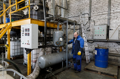 Worker at vacuum distiller  photo