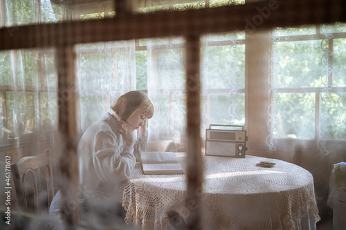 young woman reading a book at the table