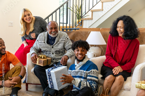 Family Smiles and Laughs during Holiday Gift Exchange photo