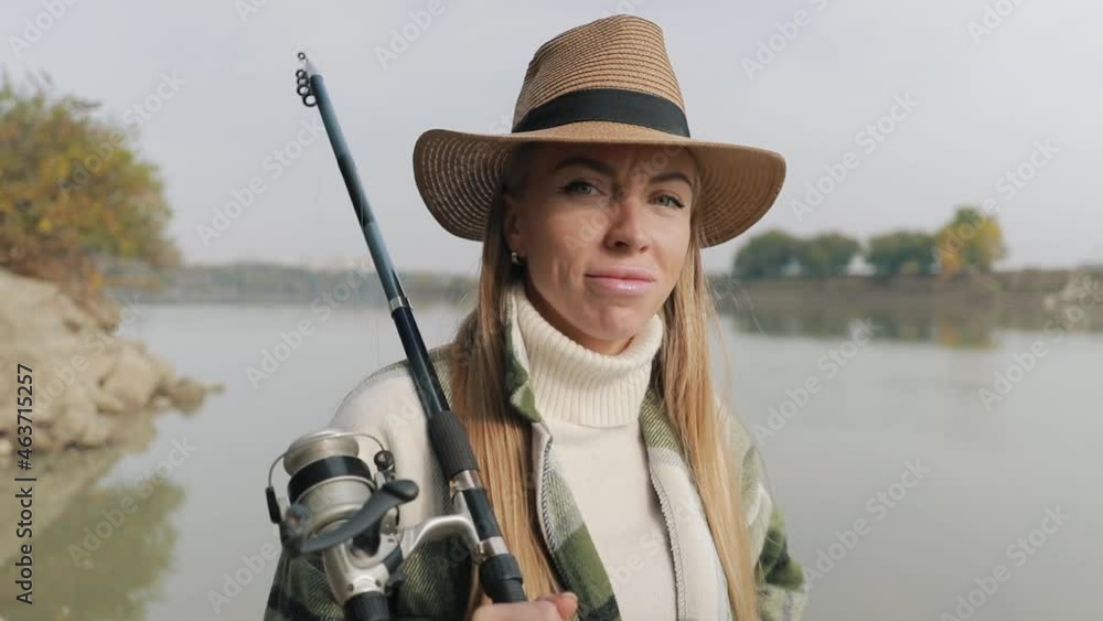 Portrait of a fisherman girl in a hat. An adult European girl looks confidently into the camera. Professional fishing lady posing close-up. Portrait of a fisherman girl in a hat. An adult European girl looks confidently into the camera. Professional fishing lady posing close-up.
