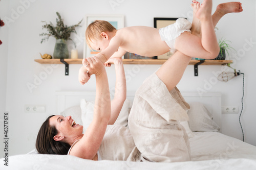 Mother and son playing in bed photo