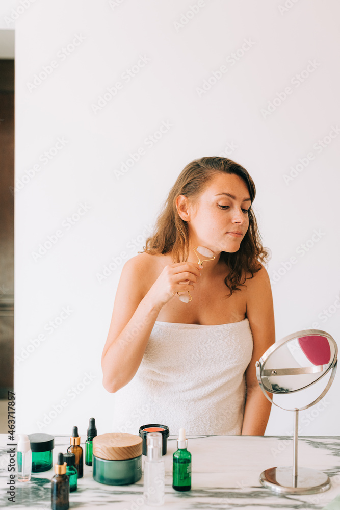 Woman making facial massage with a stone roller Woman making facial massage with a stone roller