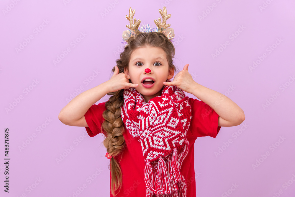 A little girl in a Christmas deer masquerade. shows hand gestures that she is calling on the phone.
