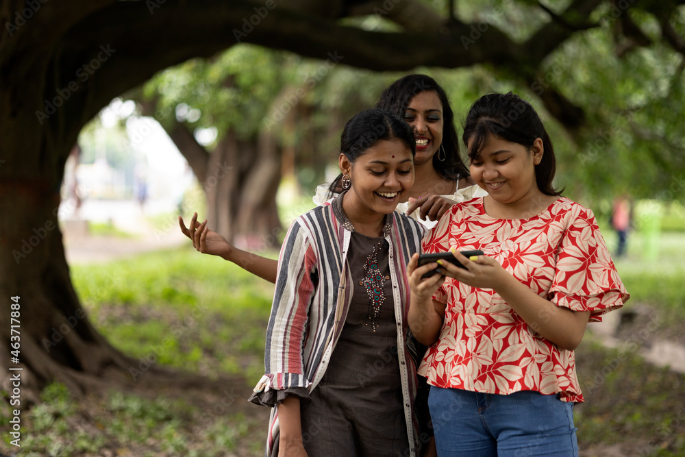 Happy Indian Girls making fun and recreation with phone