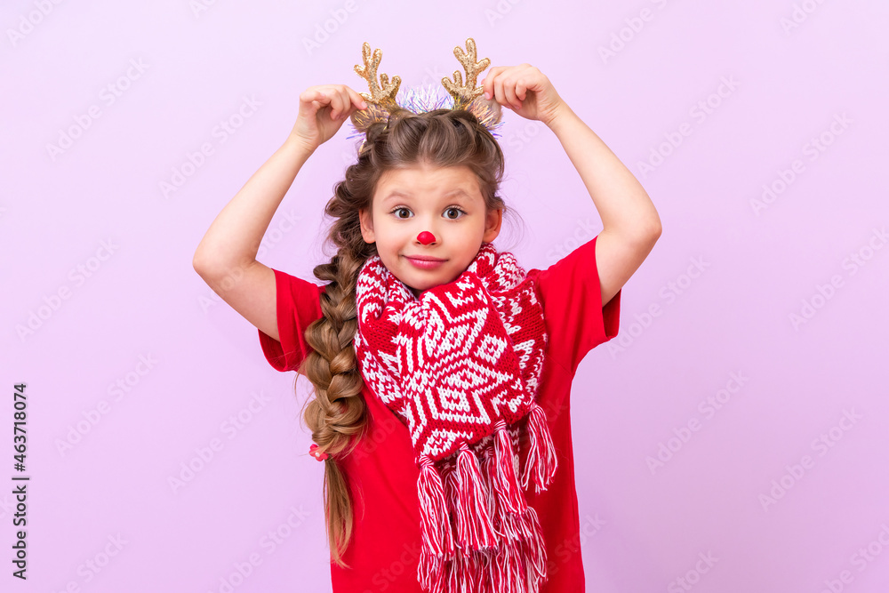 A little girl dressed as a Christmas deer holds her hands to the masquerade horns. A little girl dressed as a Christmas deer holds her hands to the masquerade horns.