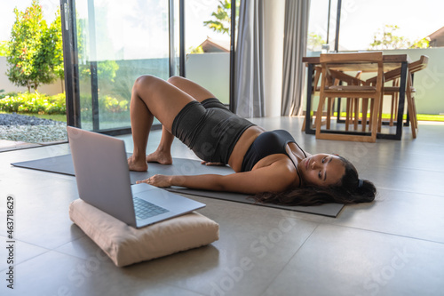 Woman Watching Video on Laptop While Exercising photo