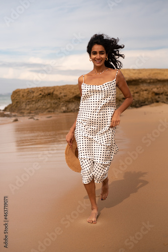 Woman happy running on an empty beach in September