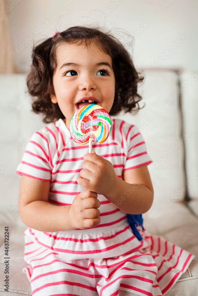 playful toddler licking lollipop playful toddler licking lollipop