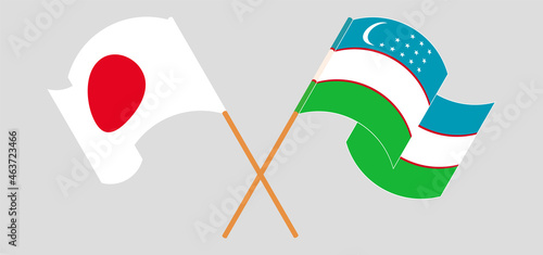 Crossed and waving flags of Japan and Uzbekistan