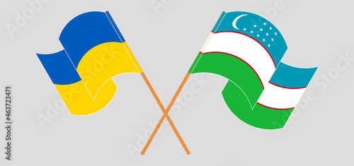 Crossed and waving flags of Ukraine and Uzbekistan