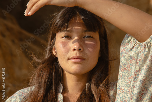 portrait of woman holding hand up to the sun