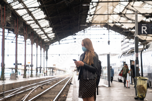 Woman Holding Phone At Public Tranport Station photo
