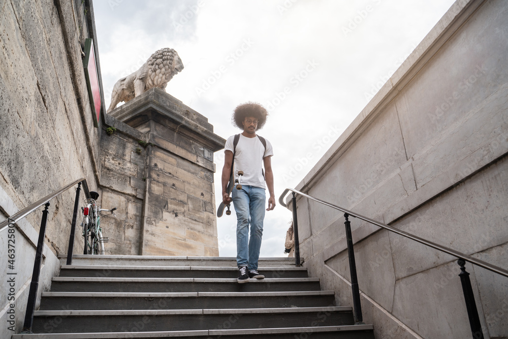 Man Carrying Skateboard Going To Metro Man Carrying Skateboard Going To Metro