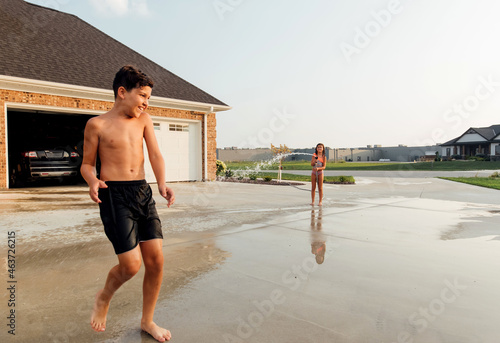 Boy shying away from being sprayed.  photo