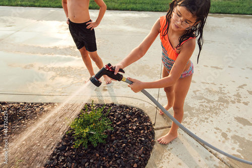 Person struggling to hold garden hose.  photo