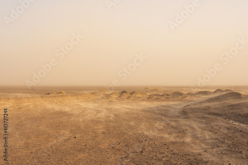 Whisps Of Sand Blow Over The Barren Desert Floor