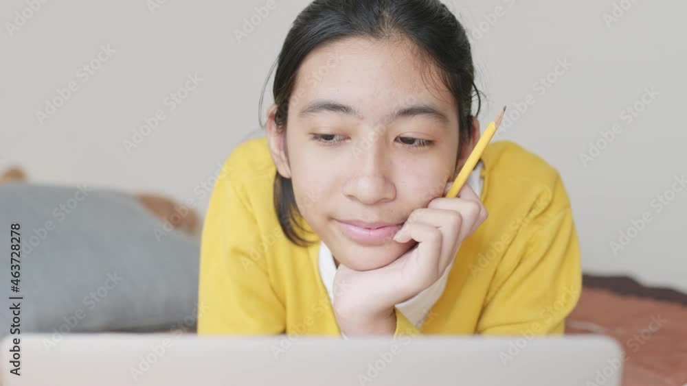 student Asian woman learning online with laptop on a bed in morning at home student Asian woman learning online with laptop on a bed in morning at home