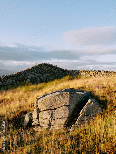 Stone and drystone wall illuminated at sunset. photo