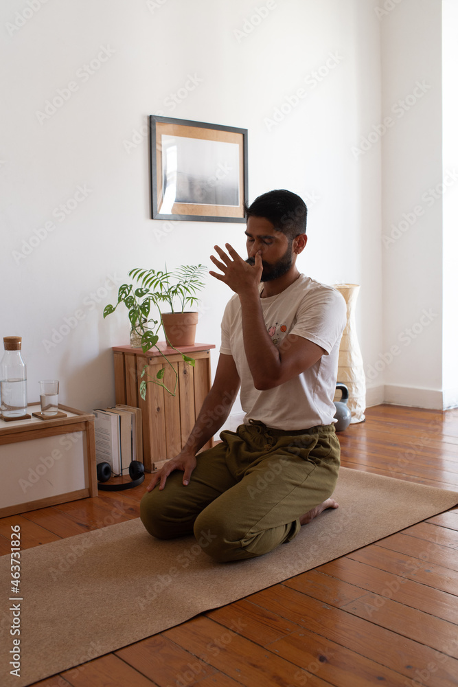 Sufi man practising pranayama in the living room Sufi man practising pranayama in the living room