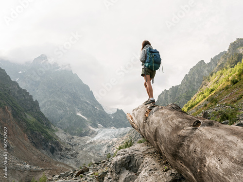 Hiker standing on the fallen tree  in mountain area photo