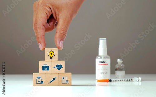 Idea light bulb icon on wooden cube block in people's hands and health care icon. Health care planning concept and "health choice". Intelligence for health lovers.