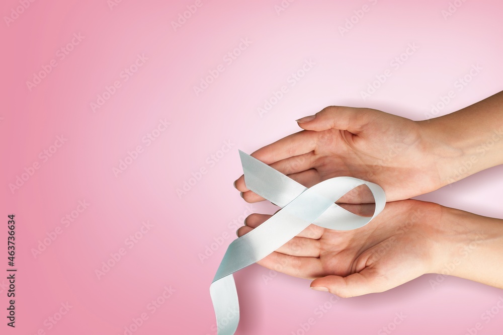 Woman hands holding pink ribbon, breast cancer awareness, October pink concept Woman hands holding pink ribbon, breast cancer awareness, October pink concept