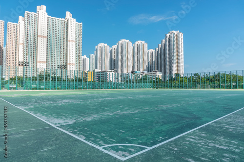 Football court and high rise residential buildings in Hong Kong city © leeyiutung