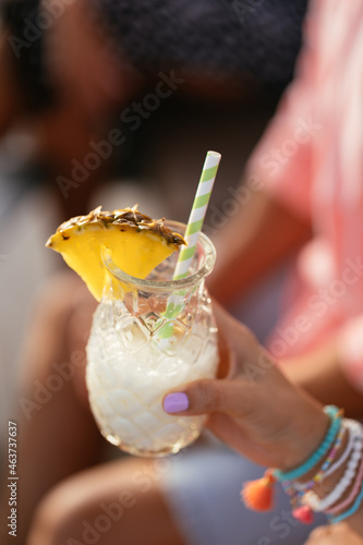 Crop woman with pina colada cocktail