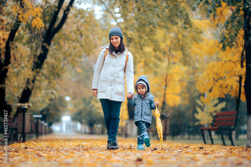 Happy Mom and Child Walking in the Park in Autumn Season