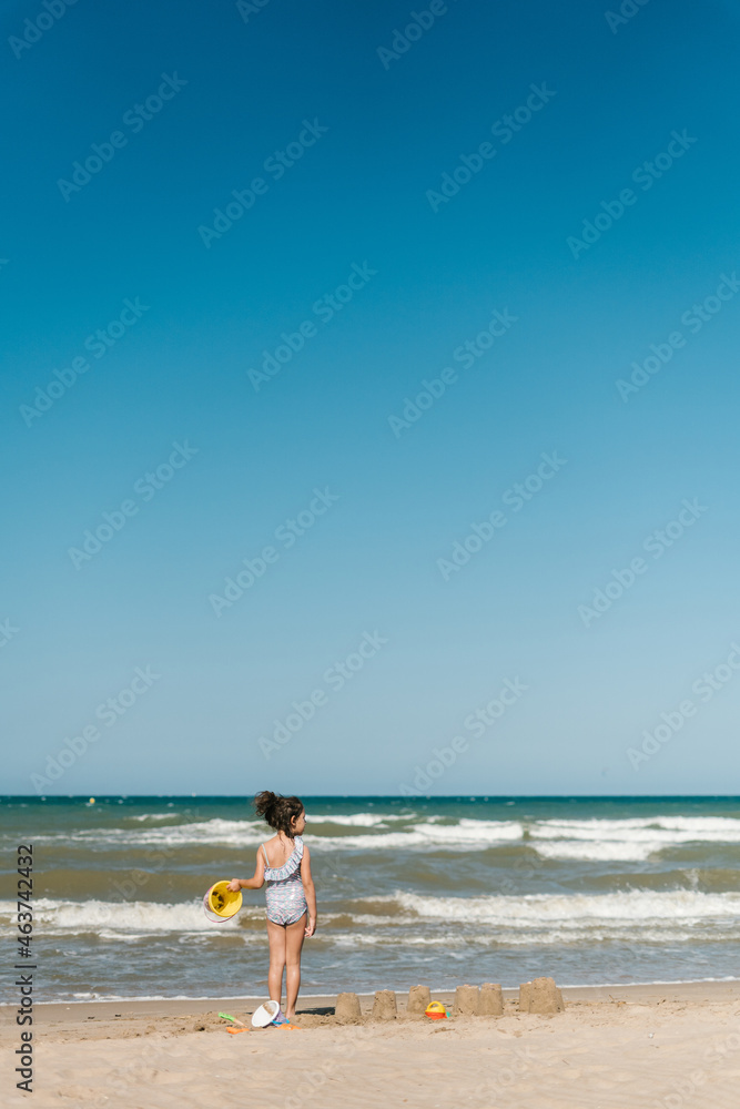 Child playing with sand on seashore