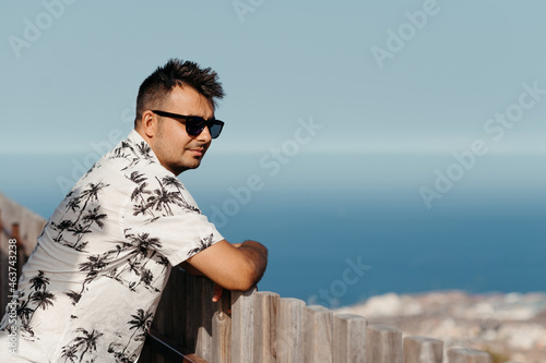 Man in sunglasses against seascape.