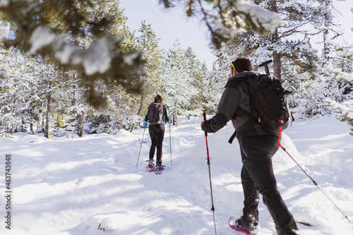 Friends using snow rackets in the snow in high mountain photo