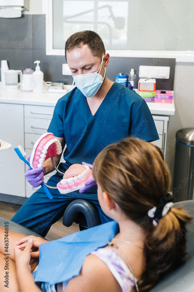 Dentist teaching kid with plastic model Dentist teaching kid with plastic model