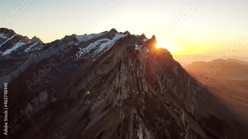 Aerial flyover over Schaefler in Appenzell, Switzerland at sunset as the sun disappears behind Santis photo