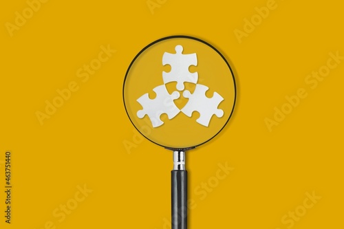 Φωτογραφία Missing puzzle piece with a magnifying glass