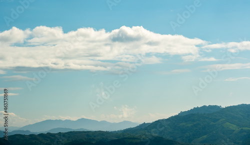 The white clouds have a strange shape and moutain.The sky and the open space have mountains below.Clouds floating above the mountains.