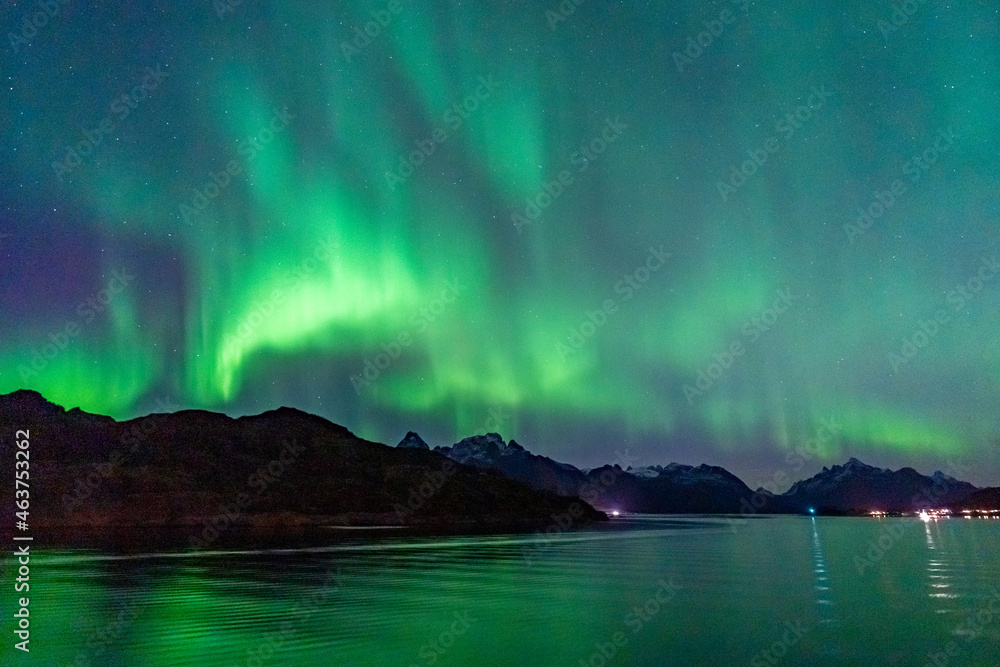 Nordlichter auf den Lofoten, Norwegen. Aurora borealis über dem Berg mit spiegelndem Licht auf dem Meer. die Lady (Aurora) tanzt in einer klaren Sternennacht am Himmel. klarer Himmel mit Sternen