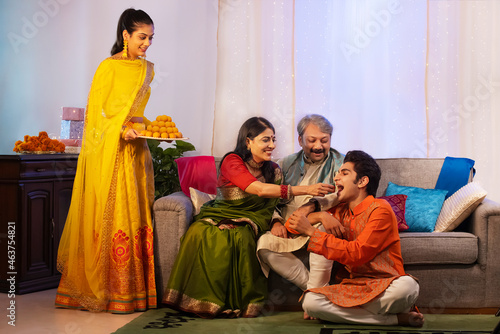 Mother offering a ladoo to her son on Diwali photo